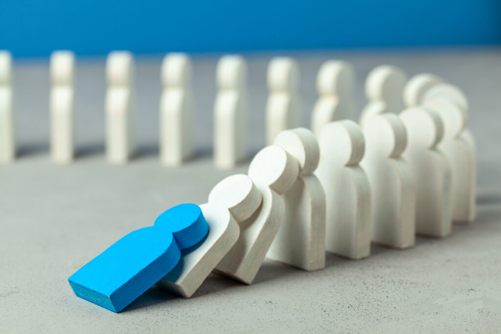 Domino effect in business. One businessman leader falls and brings down other figures of employees. System disruption.