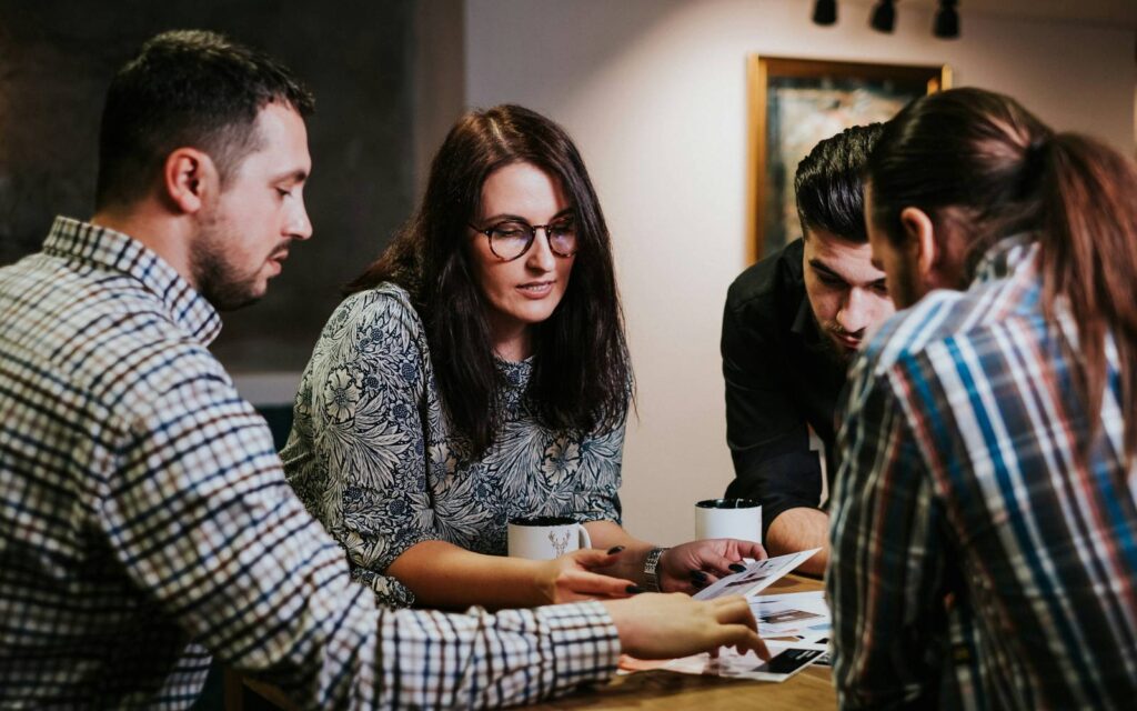 Scaling operations: team reviewing systems Small team reviewing documents together at a table while planning how the business runs